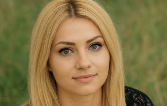 Een jonge vrouw met lang, golvend blond haar en een bloemenkroon kijkt kalm vooruit. Ze wordt omringd door spirituele symbolen zoals Lenormandkaarten,